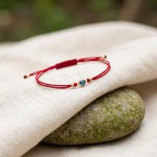 Гривна с червен конец и златен елемент синьо око BT41